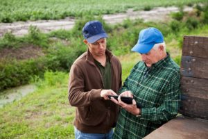 Two men using a tablet outside