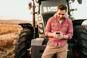 Man using phone by tractor