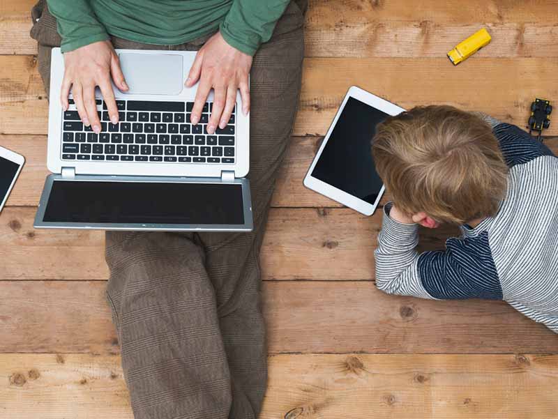 mother and son using tablet and laptop