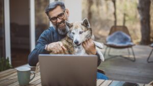 man and dog using laptop