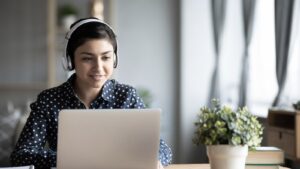 Woman streaming video at home on laptop