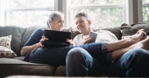 couple sitting on couch using internet