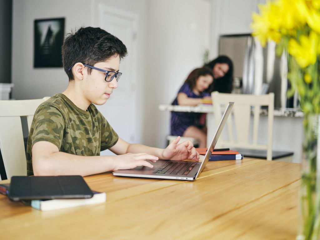 A student learning by doing schoolwork at home using a computer